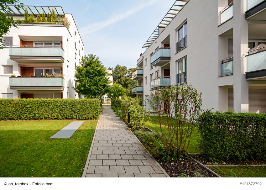  Foto mit Hausmodell auf Lupe als Symbol für Immobilienbewertung